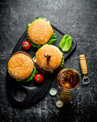 Burgers with a knife and beer in a glass.
