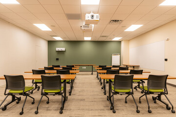 Interior of an office training, meeting, conference room with desks, chairs, and white board. ...