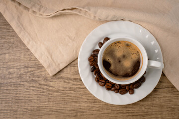 Coffee is placed in the cup on the wooden table. The hot coffee that emits fragrance after drinking will wake you up.