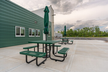 Picnic tables with umbrellas at a corporate office outdoor dining area
