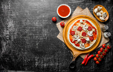 Raw pizza with tomato paste, mushrooms and sausages.