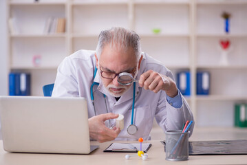 Old male doctor working in the clinic