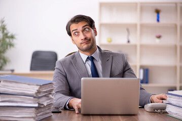 Young male employee and too much work in the office