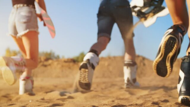 A young Asian woman is sitting on a snowboard on the sand in the outfit for a snowboard. Taking sandboard mounts. Sandboarding. Slow Motion Sports advertisement. Active sport concept.