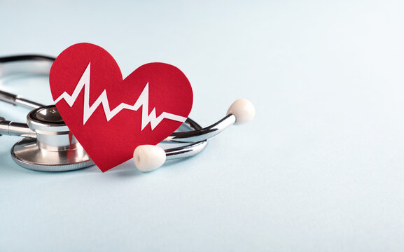 Heart health and Cardiology concept. Red heart with cardiogram chart line and medical stethoscope on pastel blue background. Closeup, copy space, banner