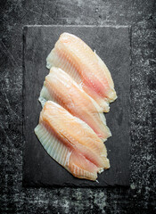 Fish fillet on a black stone Board.
