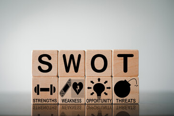 SWOT analysis ,business analysis, strategic planning, and decision making concept.,SWOT(Strengths, Weaknesses, Opportunities and Threats) word and icon on wooden cubes with copyspace.