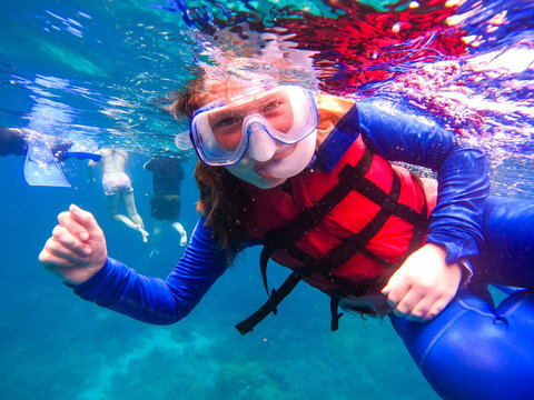 Smiling girl snorkelling in the Great Barrier Reef, Queensland, Australia