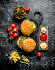 Burgers with fries,tomatoes and jalapenos in bowl .