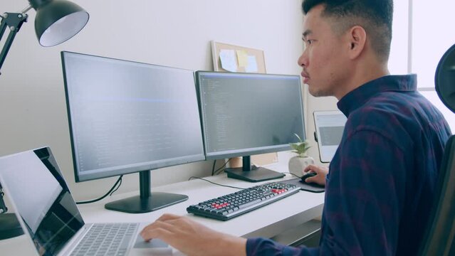 Young Asian man, developer programmer, software engineer, IT support, working on computer to check coding in bugging system