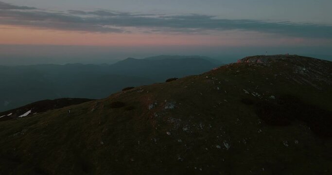 A drone shot of the mountain Peca in the early morning at the sunrise. Some orange colors and clouds on the sky.