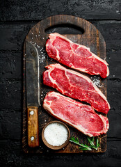 Raw steaks of juicy beef with salt.