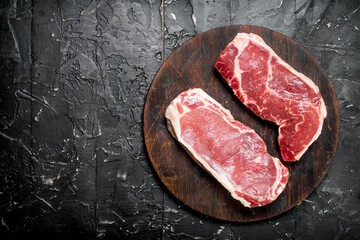 Raw beef steaks on cutting Board.