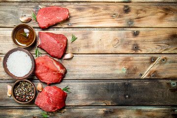 Raw meat. Sliced pieces of beef with spices and herbs.