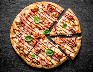 Sliced barbecue pizza with spinach leaves.