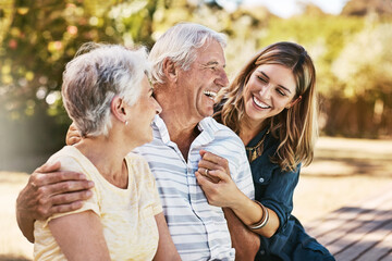 Family, senior parents and woman holding with care, love and hug bonding outdoor in a park. Smile, happy person and people in retirement with adult daughter together with bokeh in nature in summer - Powered by Adobe