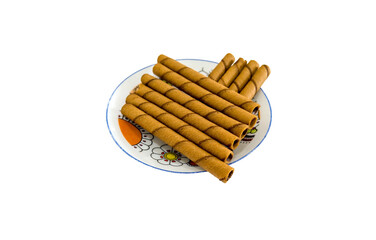 Chocolate or coffee flavored wafers rolls on white dish