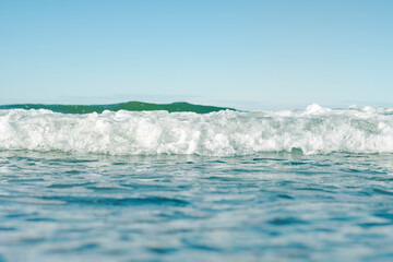 Close-up of the sea surface in soft focus. Warm waves of the ocean. Background on the theme of a pleasant romantic holiday. Beach vacation from work.