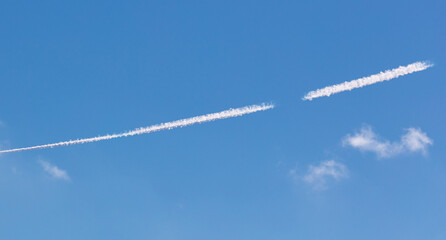 White lines from an airplane against a  sky.