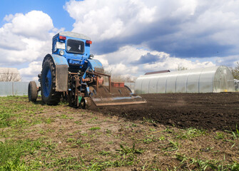 Fototapeta premium The tractor plows the soil on the field