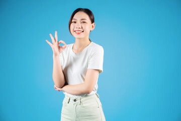 Portrait of young Asian woman standing on blue background