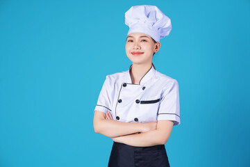 Portrait of young Asian female chef on background