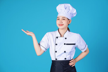 Portrait of young Asian female chef on background