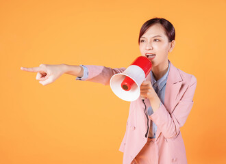 Photo of young Asian businesswoman holding megaphone on background