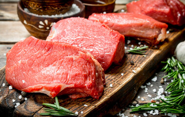 Raw meat. Pieces of fresh beef with spices and herbs .