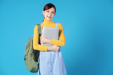 Obraz premium Young Asian student posing on blue background