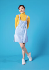 Full length photo of young Asian girl standing on blue background