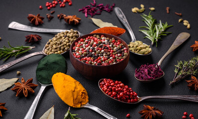 Variation of spices in metal spoons paprika, turmeric, cardamom, a mixture of allspice, thyme and rosemary