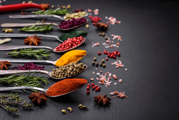 Variation of spices in metal spoons paprika, turmeric, cardamom, a mixture of allspice, thyme and rosemary