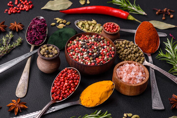 Variation of spices in metal spoons paprika, turmeric, cardamom, a mixture of allspice, thyme and rosemary