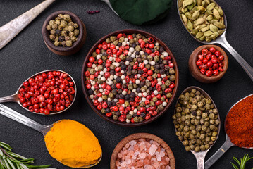 Variation of spices in metal spoons paprika, turmeric, cardamom, a mixture of allspice, thyme and rosemary