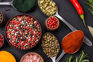 Variation of spices in metal spoons paprika, turmeric, cardamom, a mixture of allspice, thyme and rosemary