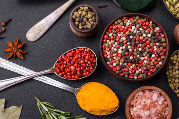 Variation of spices in metal spoons paprika, turmeric, cardamom, a mixture of allspice, thyme and rosemary