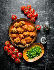Meat balls with tomatoes and chopped greens in a bowl.