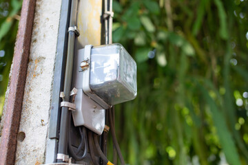 The electricity meter is mounted on a concrete pole.