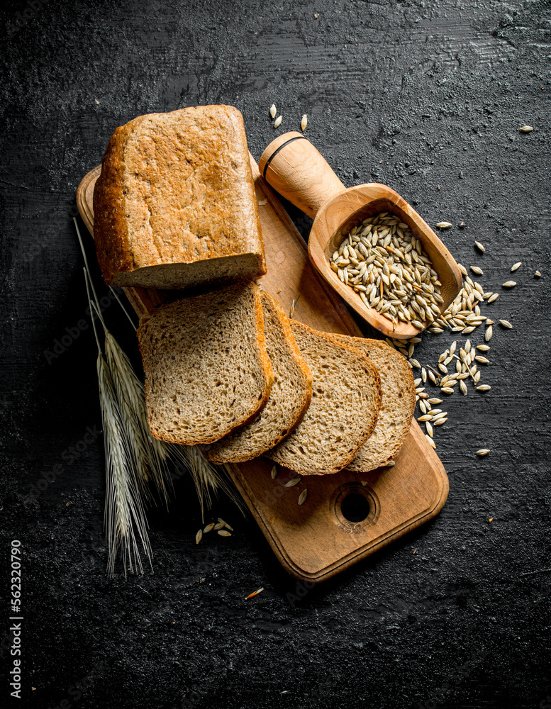 Poster Pieces of bread on a cutting Board with spikelets and grain.