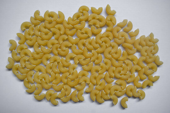Background from macaroni pipa rigata. Raw, uncooked. Top view, close-up. Isolated white background