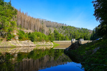 Oker reservoir near Altenau in the Harz Mountains. View from the Okertalsperre to the Oker See and the surrounding landscape. Idyllic nature by the water.
