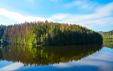 Obraz premium Oker reservoir near Altenau in the Harz Mountains. View from the Okertalsperre to the Oker See and the surrounding landscape. Idyllic nature by the water. 