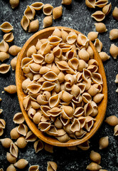 Pasta background. Dry pasta conchille in bowl.