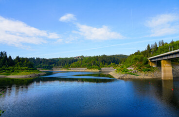 Obraz premium Oker reservoir near Altenau in the Harz Mountains. View from the Okertalsperre to the Oker See and the surrounding landscape. Idyllic nature by the water. 