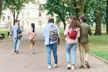 group of student friends walking through the park.