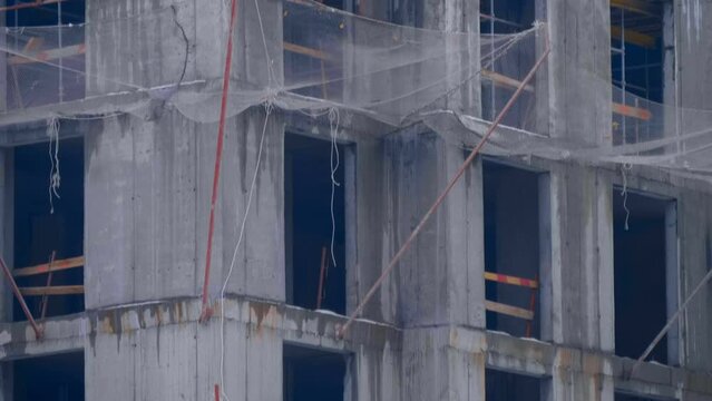 Construction site, where a modern beautiful multi-storey building is being erected by casting a monolith into a formwork reinforced with metal reinforcement. The crane carries the necessary constructi