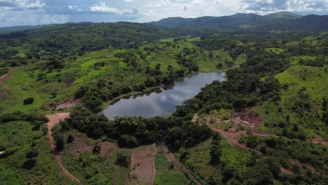 Vista aerea de lago rodeado de arboles verdes en el campo
