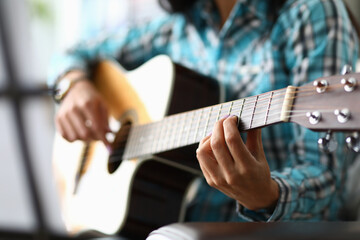 Woman hands playing guitar closeup. Learning to play acoustic guitar