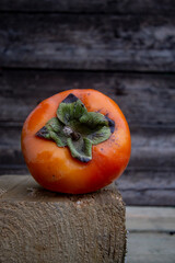 big ripe orange persimmon on wooden background
